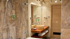 A bathroom with a large bathtub, a shower, a vanity with a mirror, and a towel rack. - Capitolina (Cluj-Napoca)