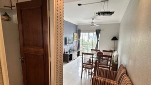 Un vaste espace de vie comprenant une table à manger, des chaises, un canapé et un ventilateur de plafond.