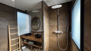 Une salle de bain moderne avec une douche Ă parois de verre, un meuble-lavabo en bois et un miroir.