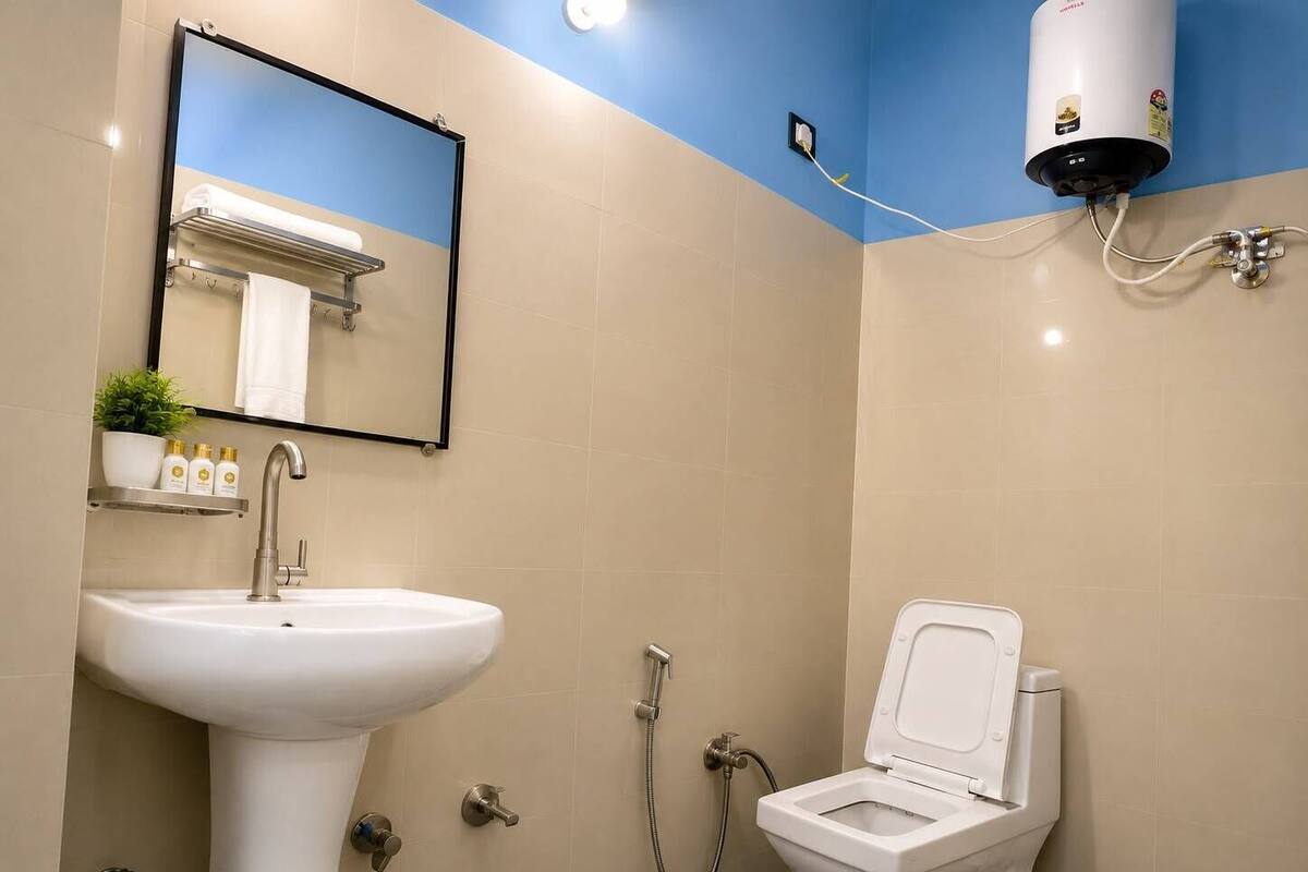 Un baño con lavamanos, inodoro y espejo.