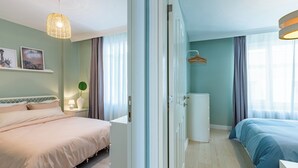 A modern hotel room with a bed, bedside table, lamp, and a view of the city. - Azure Deluxe • Central Bosphorus View Flat (Beyoglu)