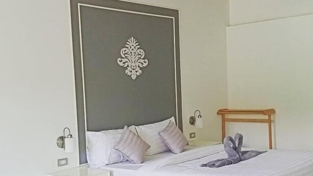 Un dormitorio moderno con cama, mesita de noche y un elemento decorativo en la pared.