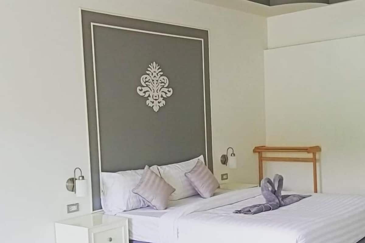 A modern bedroom with a bed, nightstand, and decorative wall piece.