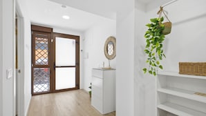 A hallway with a white cabinet, a wicker basket on a shelf, and a hanging plant. - Accessible Loft | Smart TV | Air Conditioning | Coffee | 2 people (València)