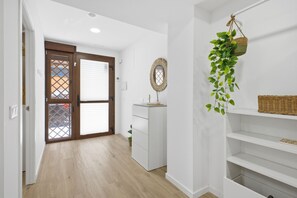 A hallway with a white cabinet, a wicker basket on a shelf, and a hanging plant. - Accessible Loft | Smart TV | Air Conditioning | Coffee | 2 people (València)