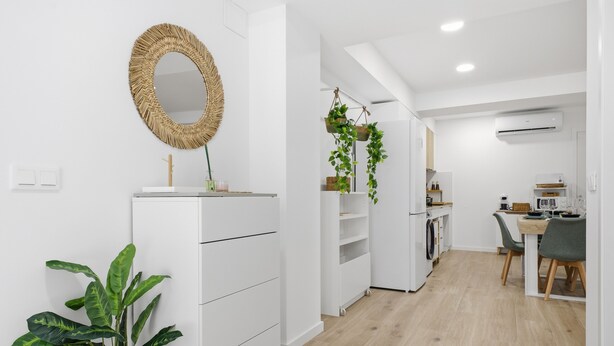 A modern kitchen with white cabinetry, a hanging plant, and a dining area with a table and chairs. - Accessible Loft | Smart TV | Air Conditioning | Coffee | 2 people (València)