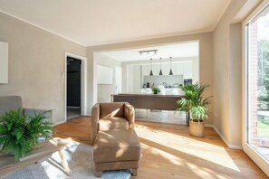 Ein modernes Wohnzimmer mit einer Couch, einem Couchtisch und einer Topfpflanze.