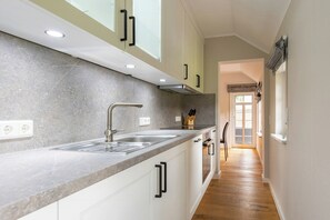 Eine moderne Küche mit Granitarbeitsplatte, Edelstahlspüle und weißen Schränken.
