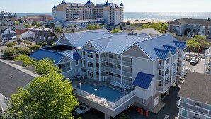 A hotel with a pool, multiple balconies, and a view of the beach.