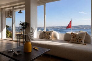 Ein modernes Wohnzimmer mit einer Couch, einem Couchtisch und einer Vase mit Blumen.