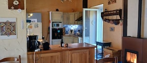 Une cuisine avec des meubles de rangement en bois, une cuisiniÚre, un four à micro-ondes et une machine à café.