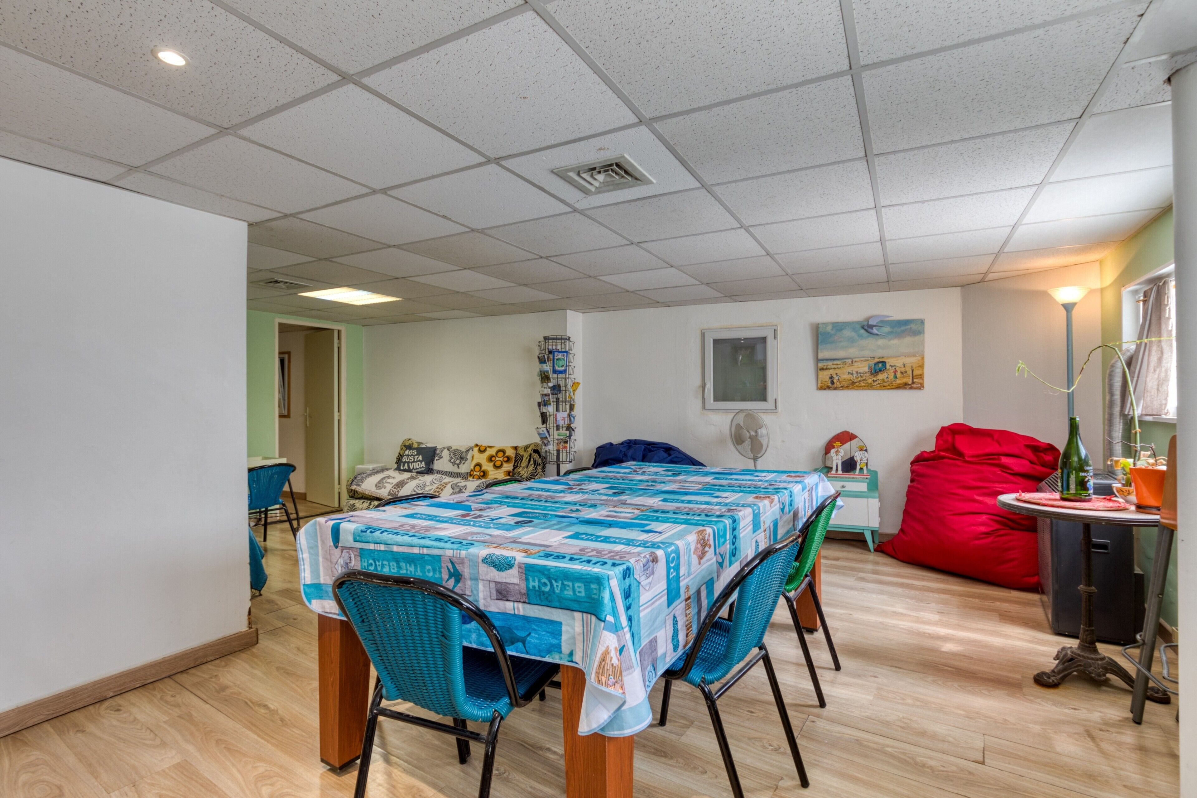 Een eethoek met een tafel, afgedekt met een blauw-witte tafelkleed, omringd door stoelen.