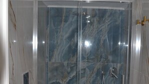 Une salle de bain avec une douche à parois de verre, des toilettes et un bidet.