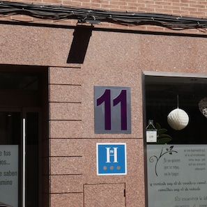 A building facade with a number 11 sign, a blue wheelchair accessibility sign, and a door entrance.