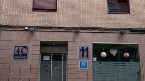 Un edificio con fachada de ladrillo, un cartel con el número '11' y una puerta con un letrero que dice 'ENTRADA'.