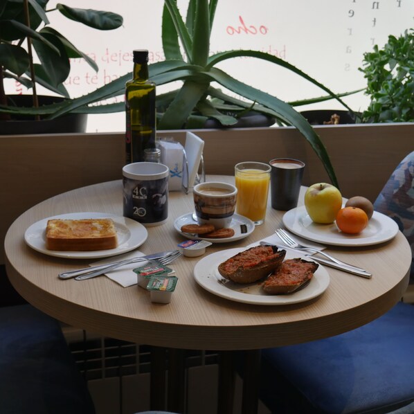 A round table with breakfast items including toast, eggs, and orange juice. - 4C Cuatro Caminos (Madrid)