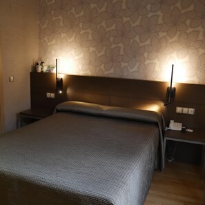 A bedroom with a bed, nightstands, a lamp, and a telephone. - 4C Cuatro Caminos (Madrid)