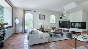 Una sala de estar con sofá, mesa de centro, televisor y chimenea.