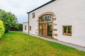 A white building with a large arched window and a door, surrounded by a well-maintained lawn. - Spacious 3BR House in Blackburn, Garden, Free WiFi & 4-Car Parking (Blackburn)