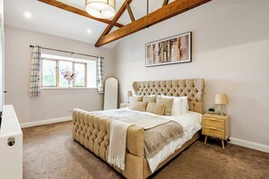 A bedroom with a large bed, wooden beams, a window with curtains, a bedside table with a lamp, and a framed picture on the wall. - Spacious 3BR House in Blackburn, Garden, Free WiFi & 4-Car Parking (Blackburn)