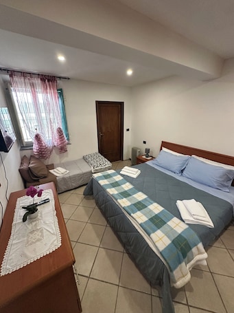 Una camera da letto con un letto, un comodino e una finestra con tende.. NidoPorcari