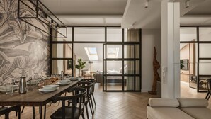 A modern interior with a dining area, a sofa, and a large window. - Kleparz modern by Fragola Apartments (Kraków)