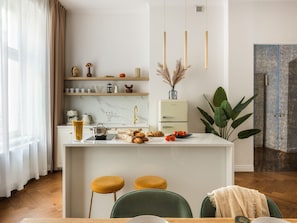 Uma cozinha moderna com bancada de mármore, pia embutida e uma pequena ilha com bancos.