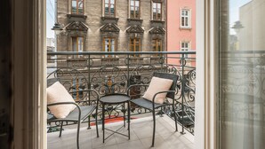 A balcony with wrought iron furniture, a view of a building with multiple windows, and a clear sky. - Kleparz modern by Fragola Apartments (Kraków)