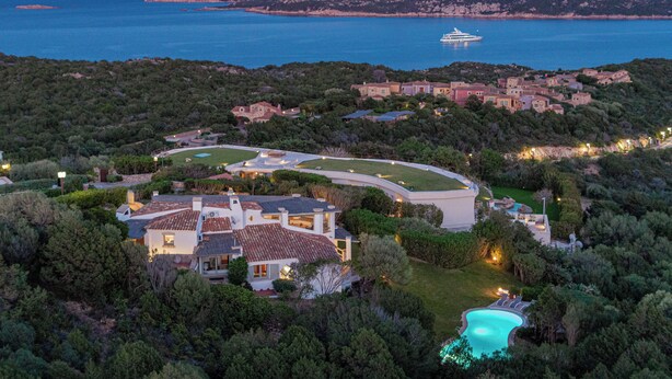 Una propiedad costera con piscina, una casa grande y vistas al mar y a las montañas.