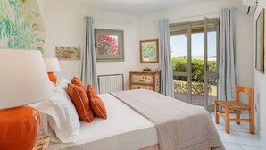 Un dormitorio con cama, una silla, un ventanal y vistas al exterior.
