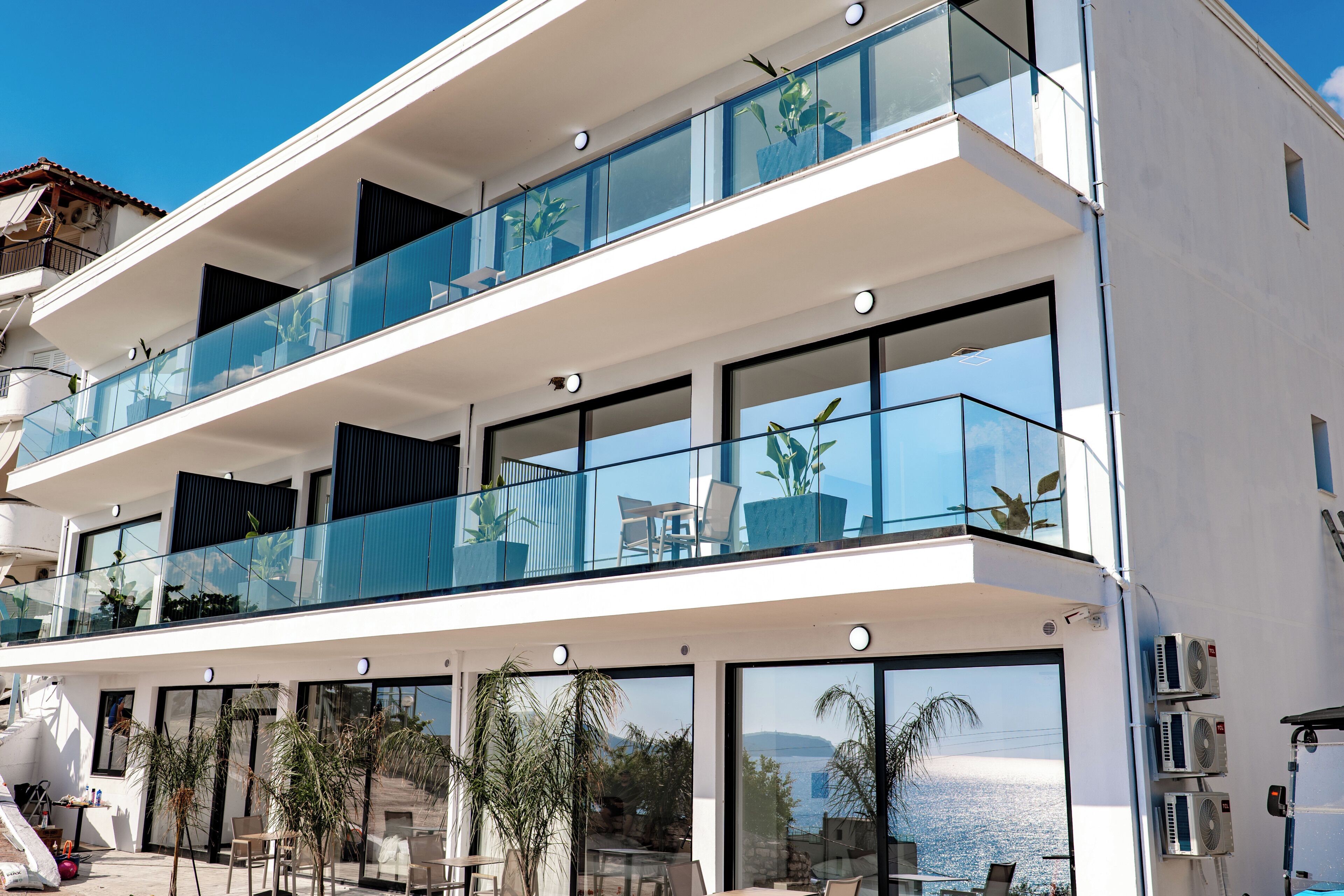 Un edificio moderno de varios pisos con balcones, ventanas amplias y terraza.