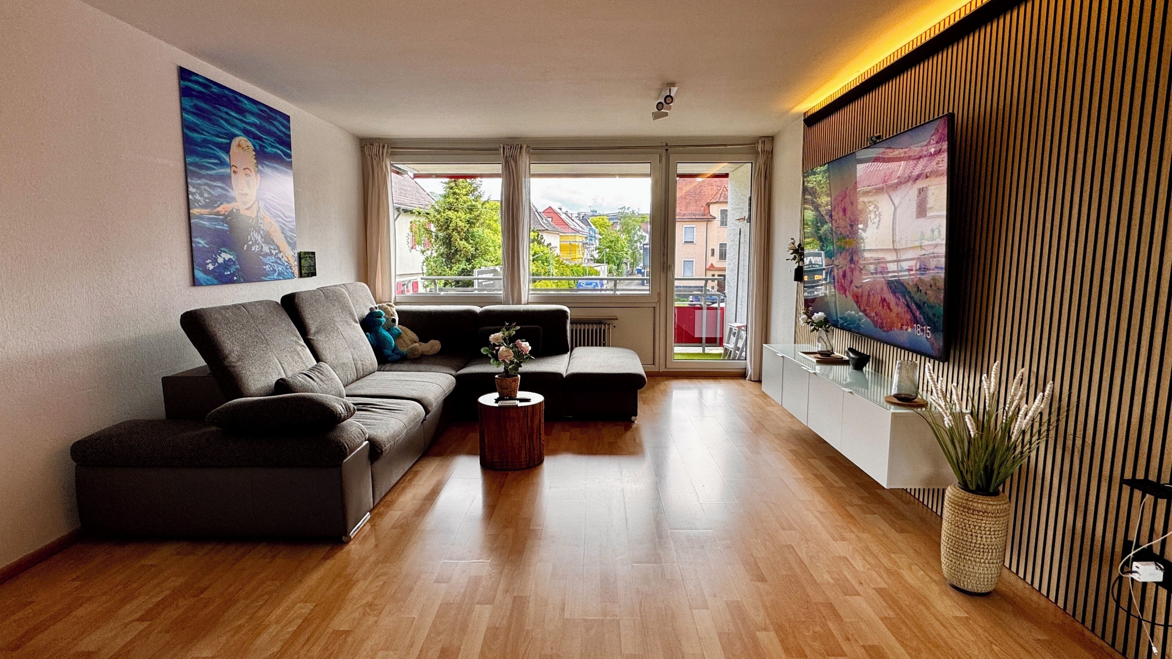 Un salon moderne avec un canapé, une table basse et un téléviseur fixé au mur.