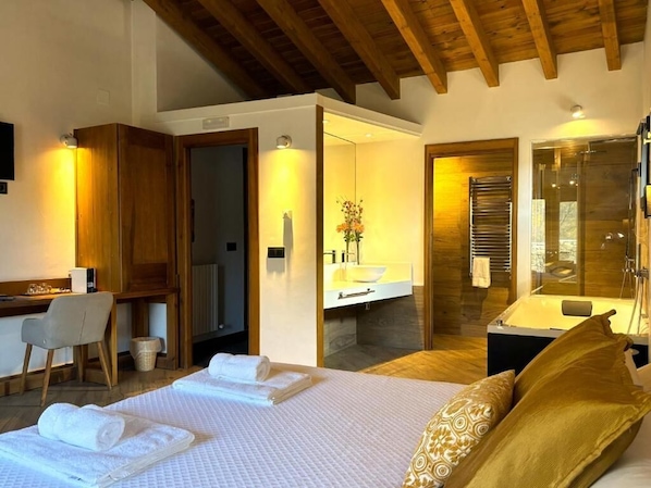 Une chambre d’hôtel comprenant un lit, un bureau, une chaise, une salle de bain et un espace douche.