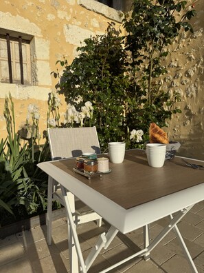 Une table avec un panier, des tasses et une miche de pain.