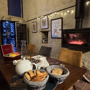 Une table à manger avec du pain, une théiÚre et des bouteilles de vin.