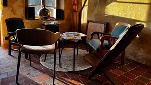 A cozy room with a brick floor, a round table, and four chairs. - RELAI VALDIEU (Courgeon)