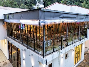 A multi-level building with outdoor seating areas, railings, and a covered section with plants. - Arambhaya Boutique Hotel - Kandy (Kandy)