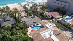 A resort with multiple swimming pools, beach access, and palm trees.