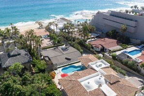 A resort with multiple swimming pools, beach access, and palm trees.