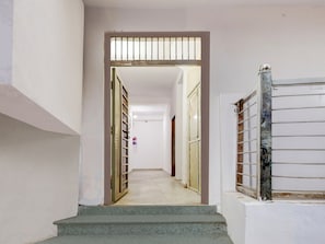 A staircase leading to a room with a white door and a barred window. - Super Collection O Sector 18 (Noida)