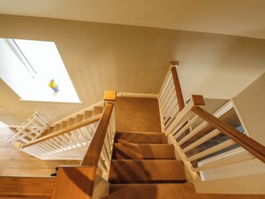 Eine Teppichstufen Treppe mit hölzernen Geländern und einem Oberlicht.