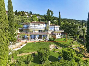Eine großzügige, mehrstöckige Villa mit weitläufigem Außenbereich, inklusive Terrasse und Garten.