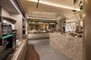 Una cocina moderna con una cafetera, una encimera con alimentos y una planta colgante.