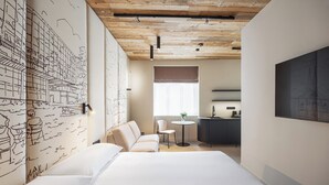 A modern hotel room with a wooden ceiling, a large bed, a desk with a chair, a small round table, and a large window. - Origin Prague (Prague)