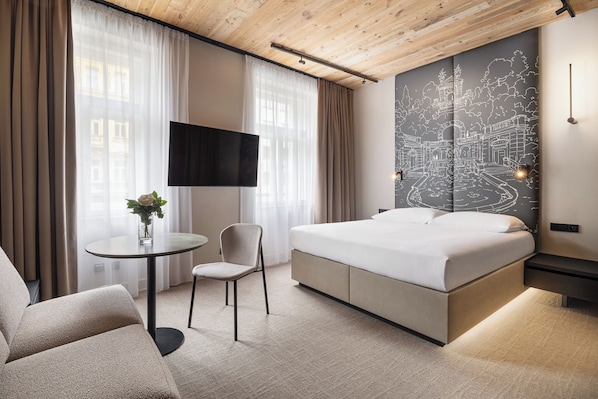 Une chambre d’hôtel moderne équipée d’un lit, d’une télévision, d’un bureau et d’une chaise.