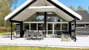 A modern building with a covered patio area, large windows, and outdoor seating. - 4 Star Holiday Home in Silkeborg (Silkeborg)