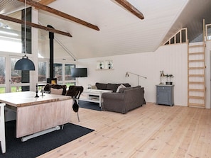 A spacious living area with a wooden floor, a dining table, a sofa, and a TV. - 4 Star Holiday Home in Silkeborg (Silkeborg)
