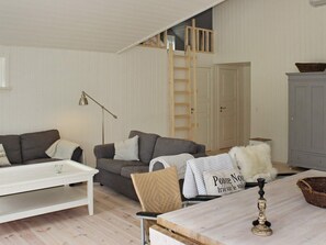 A cozy living room with a sofa, a coffee table, a lamp, a ladder, and a cabinet. - 4 Star Holiday Home in Silkeborg (Silkeborg)