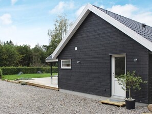 A modern building with a dark exterior, a white door, and a small window. - 4 Star Holiday Home in Silkeborg (Silkeborg)