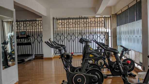 Un gimnasio con bicicletas estáticas, cinta de correr y equipo de ejercicio.